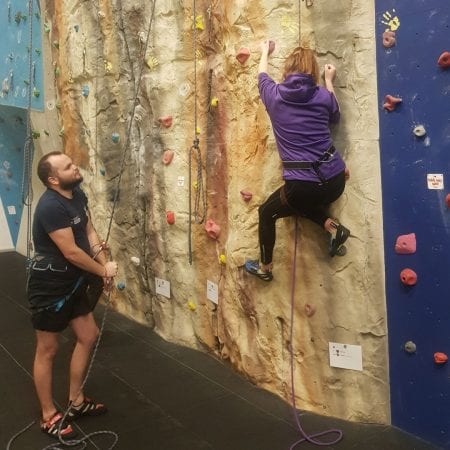 Image shows a student at the climbing wall