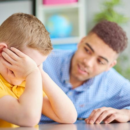 teacher supporting an upset boy