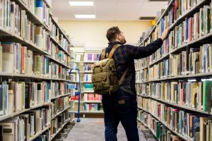 A man selecting books at Plymouth Marjon University