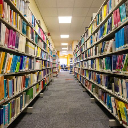 An aisle of books in the Plymouth Marjon University Library